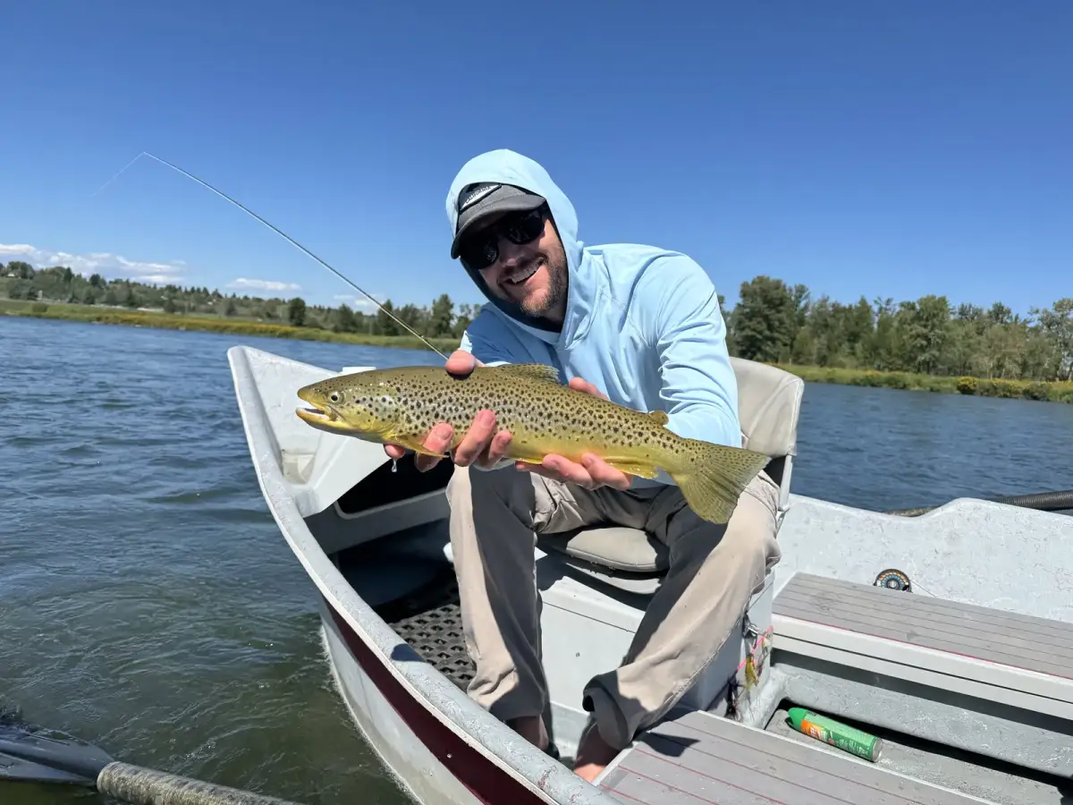 Happy fishing client with caught trout on Bow River