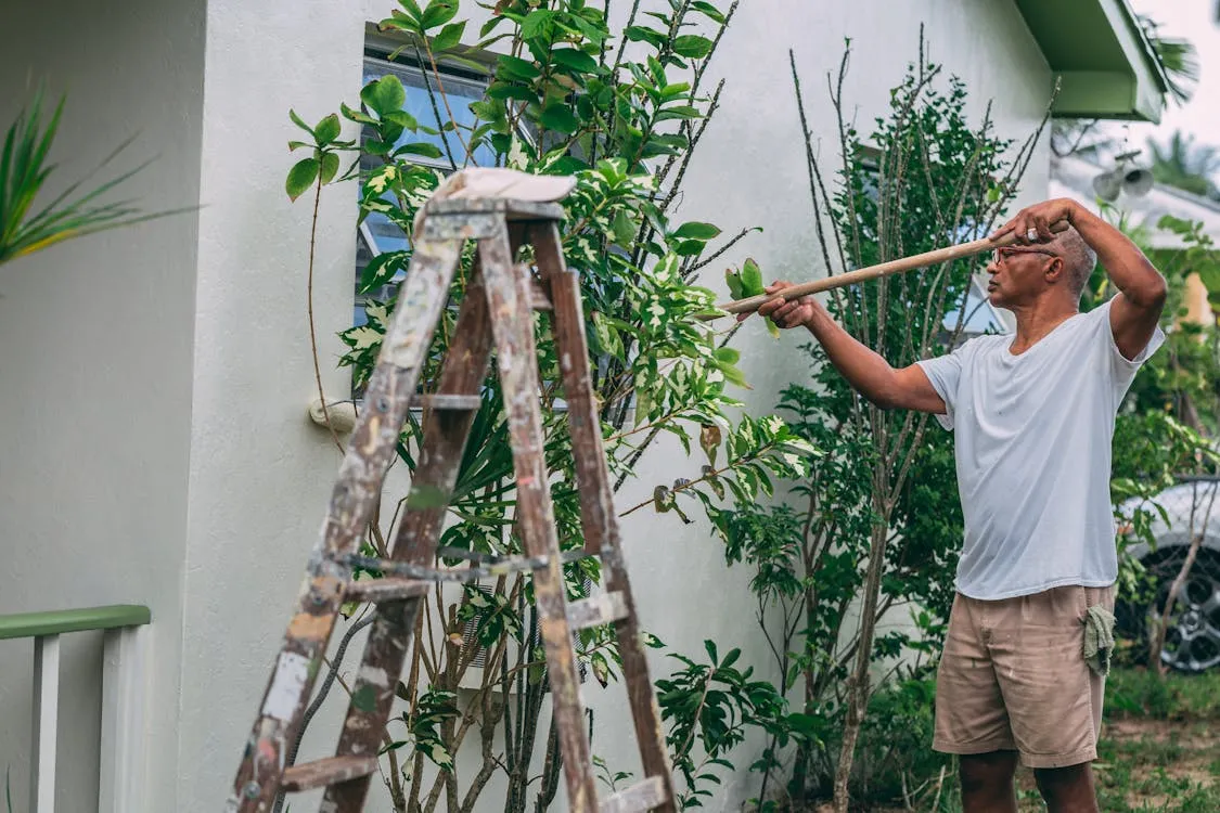 Professional painting contractor completing a residential exterior paint job with premium finish