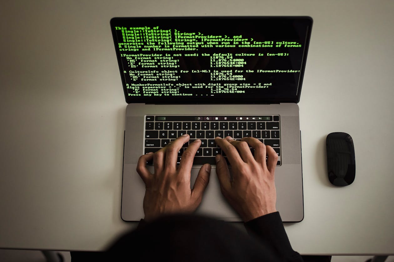 Developer hands typing on a laptop with terminal open