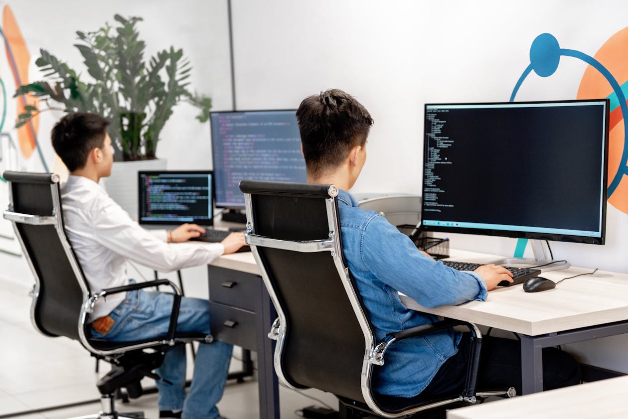 Developers working at multiple screens with code
